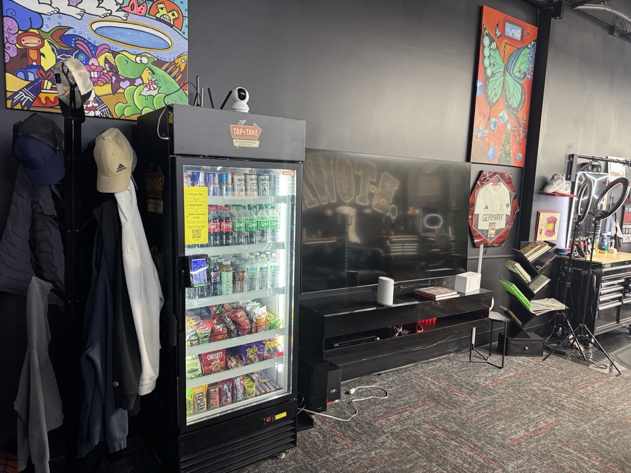 A Tap N Take smart vending cooler stocked with drinks and snacks at Faded Barbershop in Bloomington, Indiana