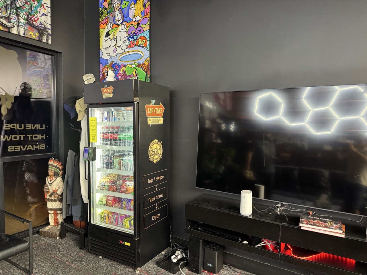 A fully wrapped Tap N Take smart vending cooler stocked with drinks and snacks at Faded Barbershop in Bloomington, Indiana
